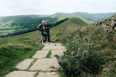 A hiker couple pose on the Great Ridge Walk, with the ridge itself in the background.